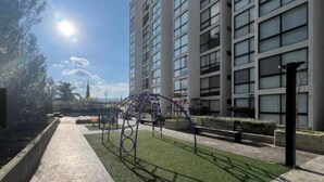 Un bâtiment moderne doté d’une aire de jeux avec une structure en métal.