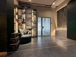 Un interior moderno con un sofá, una pared de piedra y una puerta corredera.