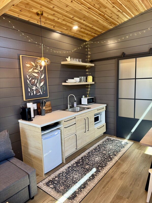 A modern kitchen with wooden cabinets, a built-in dishwasher, and a dining area with a rug.