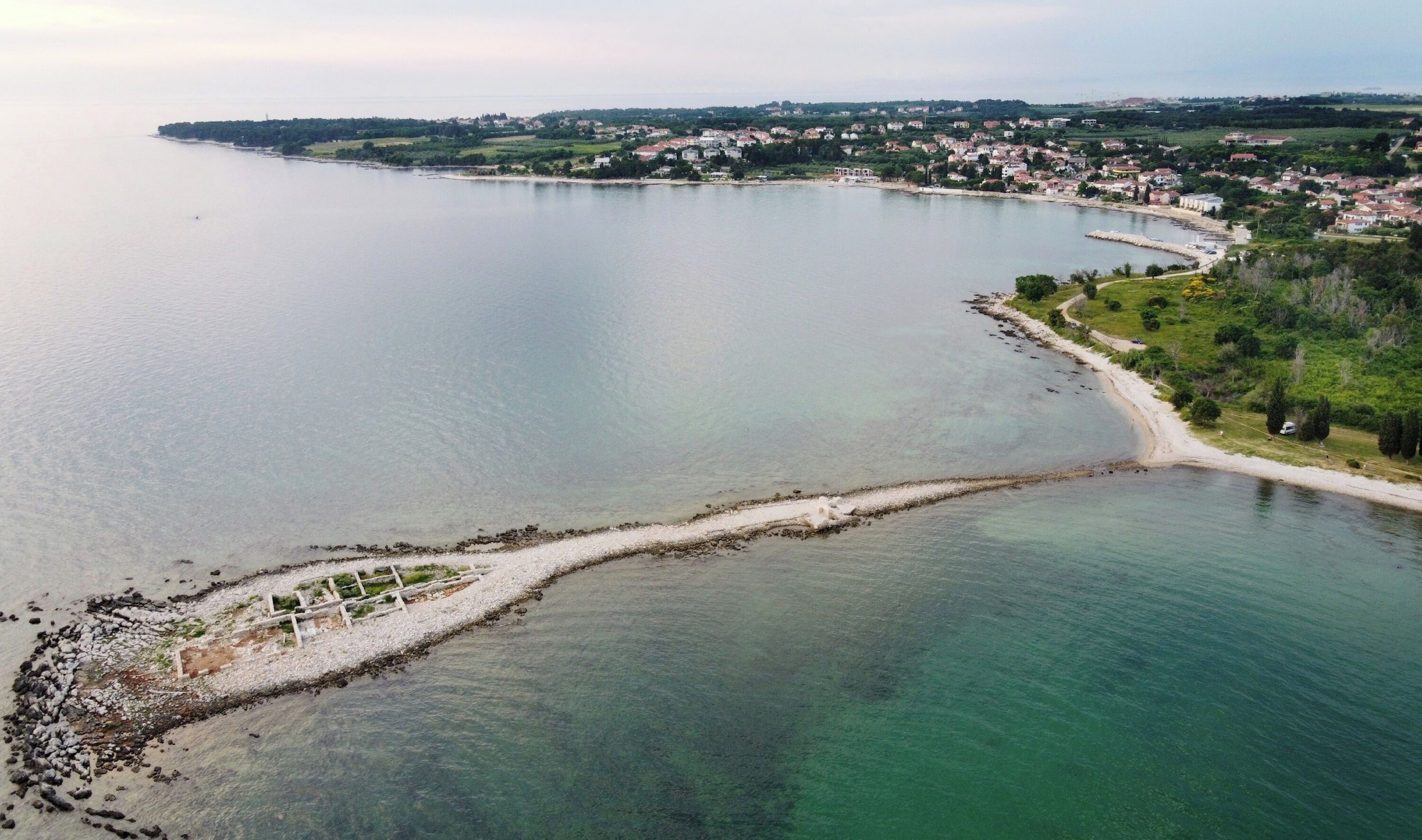 Une ville côtière offrant une vue dégagée sur la mer, une plage de sable et des immeubles résidentiels le long de la côte.