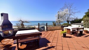 A patio with a grill, seating, and a view of the sea. - Practical Stay With Ocean View (Umag)