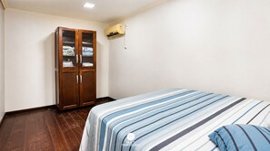 Ein Schlafzimmer mit einem Bett, einem Kleiderschrank und einer Klimaanlage.