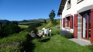 Una casa con giardino, un tavolo e sedie, e vista sulla campagna.