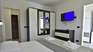 A hotel room with a bed, a wardrobe, a television, and a desk. - Charming Vacation Home With Garden (Umag)