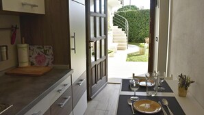 A kitchen with a dining area, a staircase leading to a garden, and a view of the outdoors. - Charming Vacation Home With Garden (Umag)