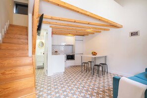 Eine moderne Küche mit weißen Schränken, einer gefliesten Spritzschutzleiste und einer Holzbalkendecke.