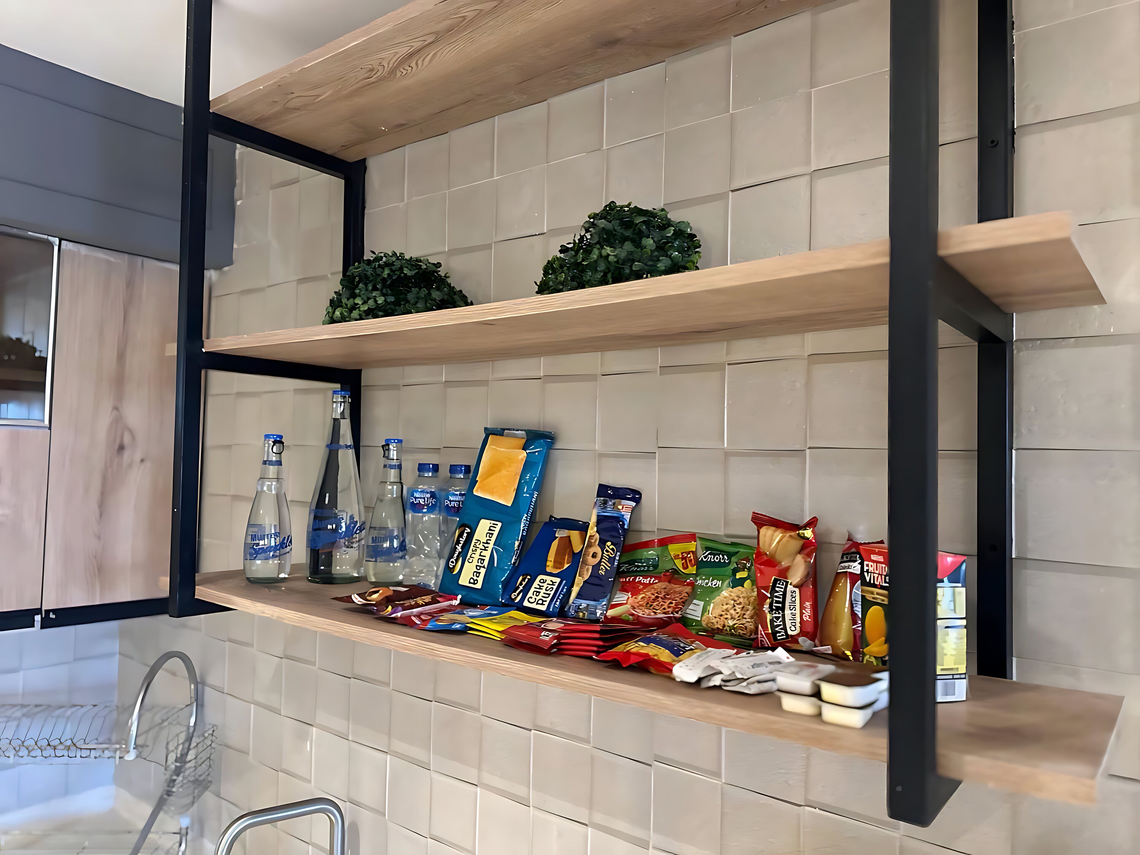A kitchen with wooden shelves, a metal rack, and various packaged food items.