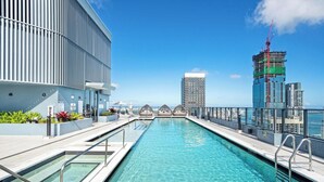 A rooftop pool with a view of the city skyline, including a tall building under construction. - Bright apartment w/ pool & workspace (Miami)