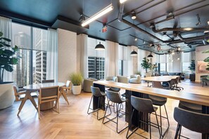 A modern office space with a large wooden table, multiple chairs, and large windows offering city views. - Bright apartment w/ pool & workspace (Miami)