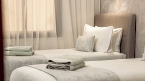 A hotel room with two beds, a large headboard, and sheer curtains. - Comfortable apartment in the heart of Guéliz (Marrakech)
