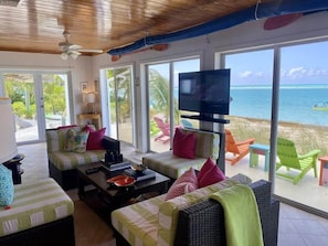 A room with a sofa, chairs, a TV, and a view of the ocean. - Sailbeach Spanish Wells (Spanish Wells)