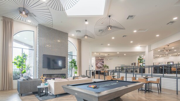 A modern living room with a pool table, comfortable seating, a flat-screen TV, and a dining area with bar seating. - Peaceful Remodeled Unit | Serene Wellness Retreat (Scottsdale)