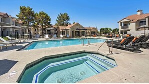 A swimming pool with lounge chairs, a hot tub, and a building with a tiled roof. - Peaceful Remodeled Unit | Serene Wellness Retreat (Scottsdale)