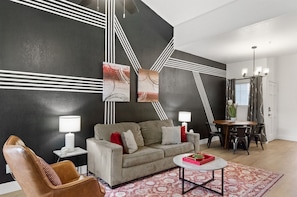 A modern living room with a sofa, a coffee table, and a dining area with a table and chairs. - Near TPC|Heated Pool| Near Shops | Dine | Museums (Scottsdale)