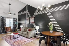 A modern living room with a sofa, coffee table, and dining table.