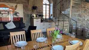 A dining area with a wooden table set for six, surrounded by wooden chairs. - Duplex Flat With a Fireplace in a Historic Vaulted Building (Grossharthau)