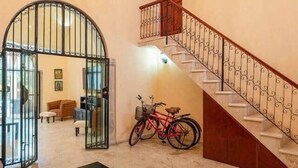 A spacious lobby with a staircase, a chandelier, a bicycle, and a coffee table. - Chez David magnificent colonial retreat (Mérida)