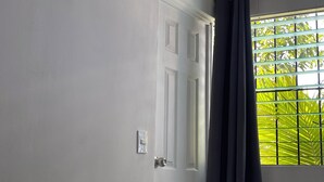 Una porta bianca con una finestra alla destra.