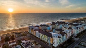 Um hotel à beira-mar com edifícios de vários andares e céu claro.