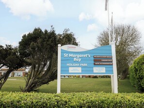 A sign for St. Margaret's Bay Holiday Park with amenities like a heated indoor pool, fully equipped gym, sauna, and spa.
