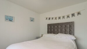 A bedroom with a large bed, a headboard, and a welcome banner. - 38 St Margarets (Dover)