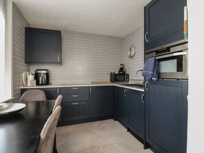 A compact kitchen with dark cabinetry, a coffee maker, a microwave, and a toaster. - 38 St Margarets (Dover)