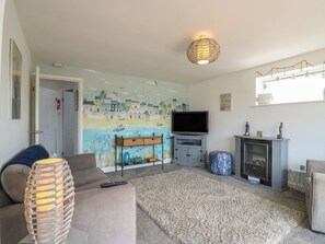 A living room with a television, sofa, and a fireplace.