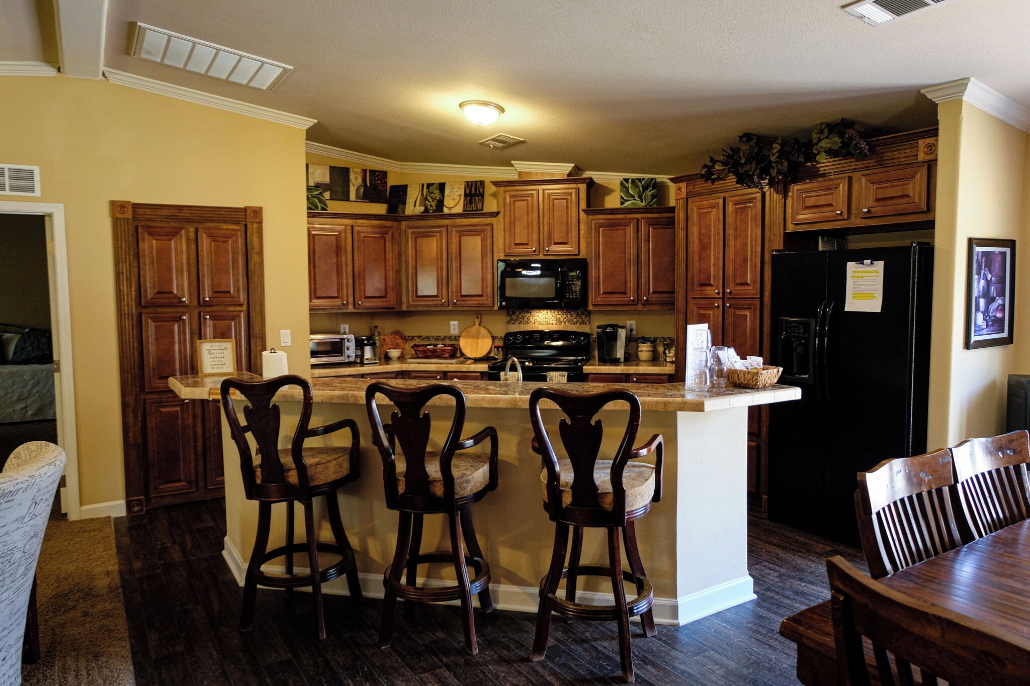 A kitchen with wooden cabinets, a microwave, a stove, and a refrigerator.