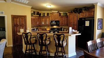 A kitchen with wooden cabinets, a microwave, a stove, and a refrigerator.