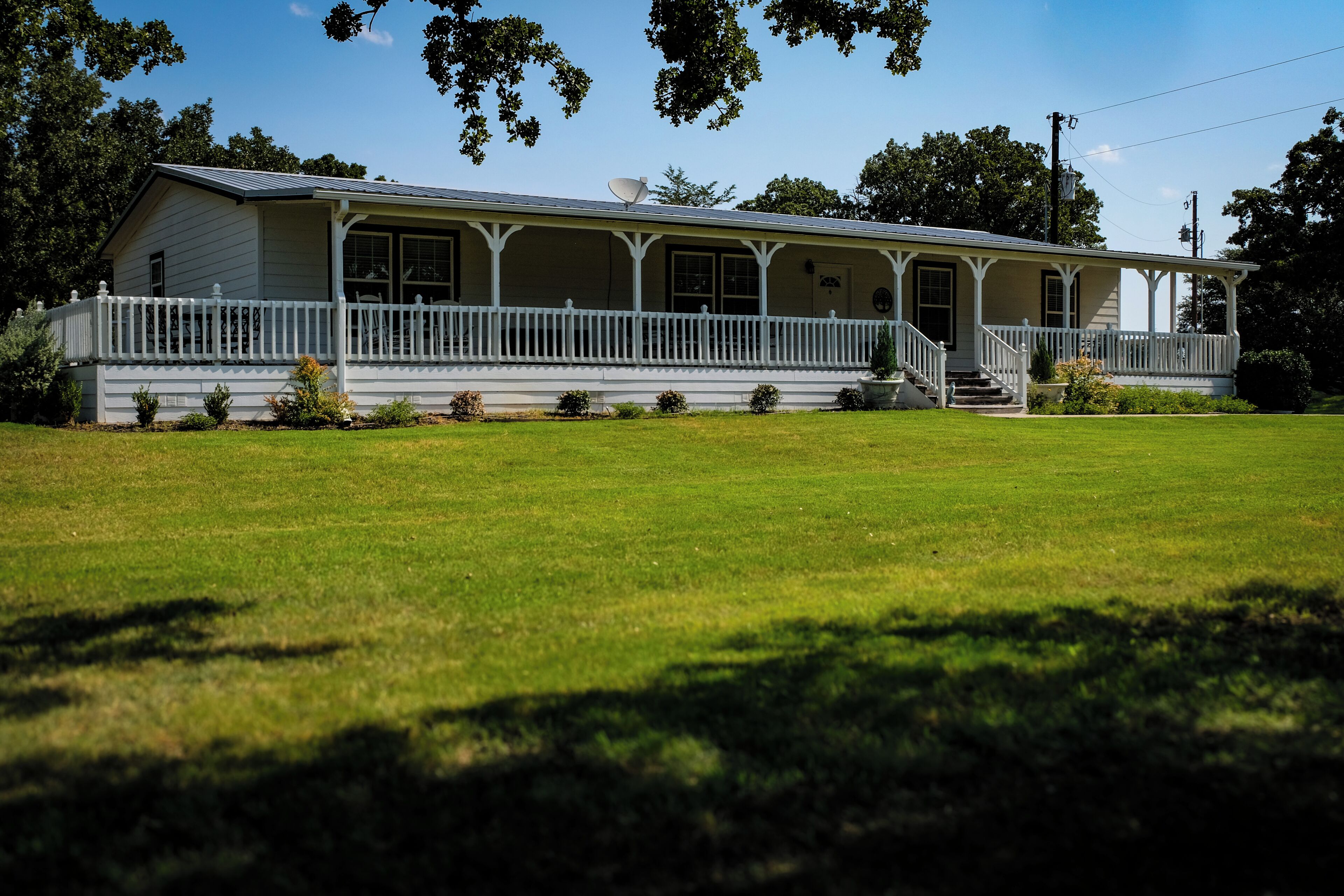 A two-story house with a porch and a large front lawn.