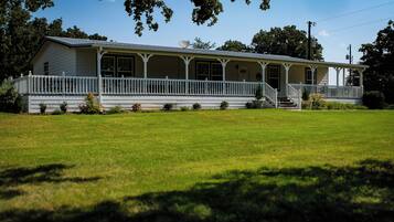 A two-story house with a porch and a large front lawn.