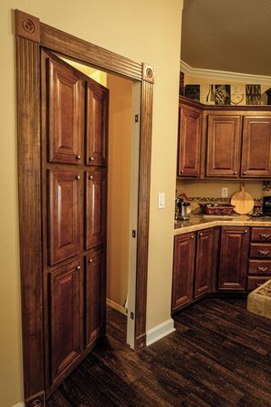 A kitchen with wooden cabinets, a countertop, and a backsplash.
