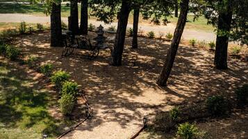 A park with a gravel path, trees, and benches.