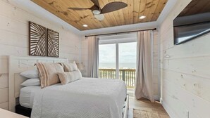 A bedroom with a bed, a ceiling fan, a window with curtains, and a view of the outdoors. - Private Pool | Gulf Views | Beachfront Access (Gulf Shores)