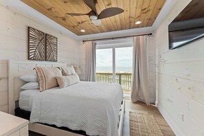 A bedroom with a bed, a ceiling fan, a window with curtains, and a view of the outdoors. - Private Pool | Gulf Views | Beachfront Access (Gulf Shores)