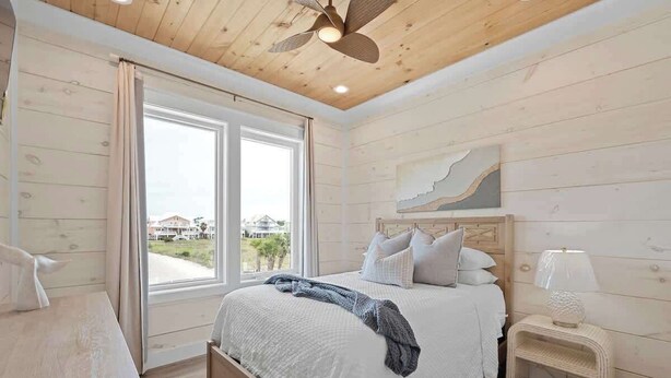 A bedroom with a bed, a nightstand, a ceiling fan, and a window with a view. - Private Pool | Gulf Views | Beachfront Access (Gulf Shores)