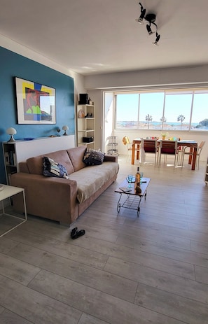 Un salon comprenant un canapé, une table basse et un coin repas avec des chaises et une table.