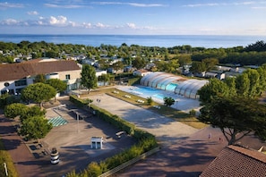 Ein Wohngebiet mit großem Schwimmbad, Häusern und Blick aufs Meer.