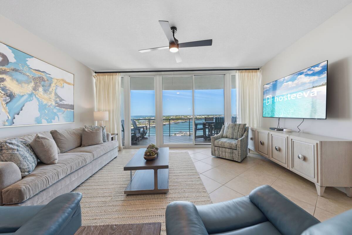 A modern living room with a sofa, armchair, coffee table, and a television.