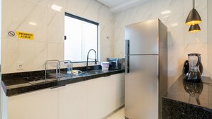 Une cuisine moderne équipée d’un réfrigérateur en acier inoxydable, d’un four à micro-ondes et d’une machine à café.