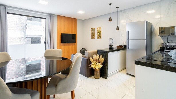 Una cocina moderna con comedor, televisor de pantalla plana y refrigerador.