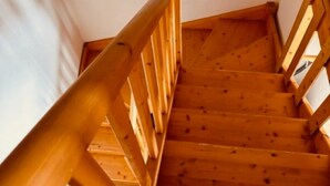 Un escalier en bois, doté d’une rampe, menant à l’étage supérieur.