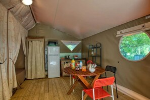 Eine kleine Küche mit Kühlschrank, Herd und Fenster.