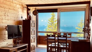 Un interno in legno con televisione, tavolo da pranzo e sedie.