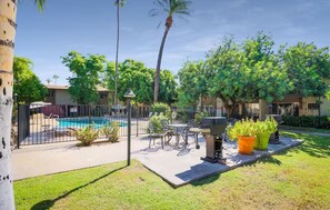 A backyard with a pool, patio furniture, and a grill area. - Southwest Meets Boho Old Town Scottsdale Townhome (Scottsdale)