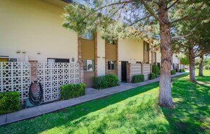 A building with a beige exterior, a white lattice fence, and a well-maintained lawn. - Southwest Meets Boho Old Town Scottsdale Townhome (Scottsdale)