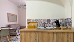 A compact kitchen with a wooden island, a sink, and a coffee maker. - Encanto Alcázar - Ole Solutions (Jerez de la Frontera)