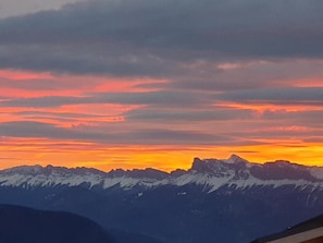 Une chaîne de montagnes sous un ciel au coucher du soleil.
