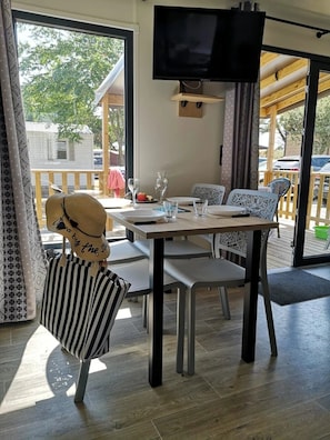 Ein Essbereich mit Tisch, Stühlen und einem Fernseher.