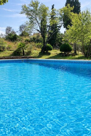 A clear blue swimming pool surrounded by trees and greenery. - Cottage · Duplex with Pool (Saint Montan)